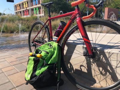 Photo of Ashley's dark red commuter bike and green backpack. 