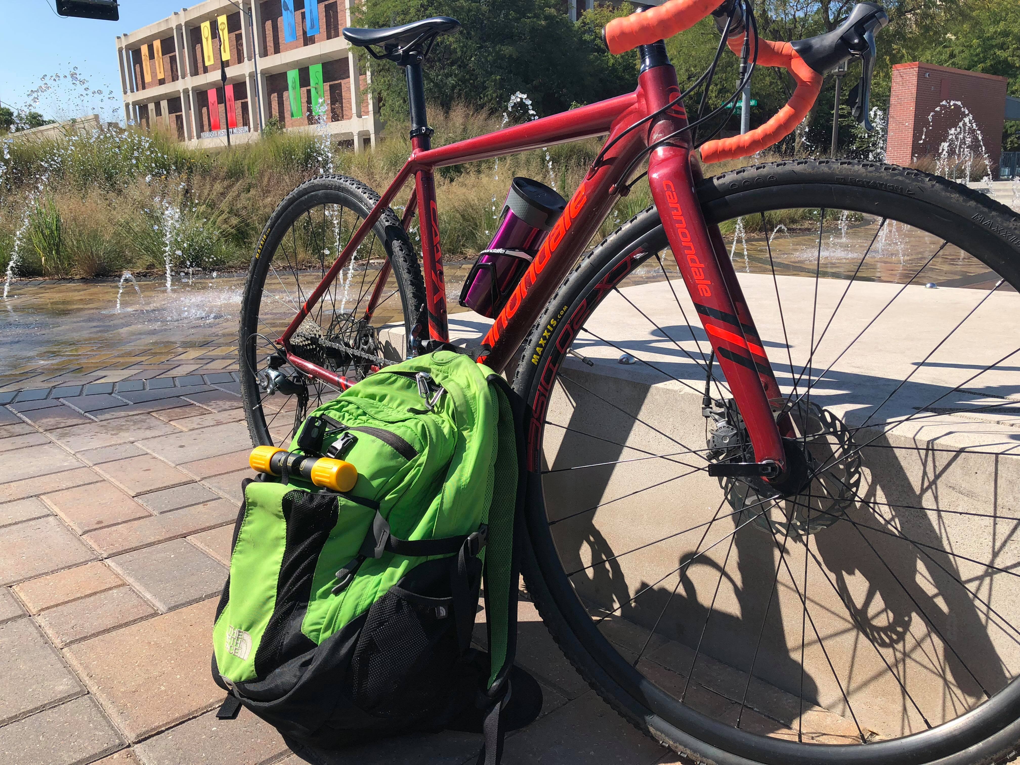 Photo of Ashley's dark red commuter bike and green backpack.